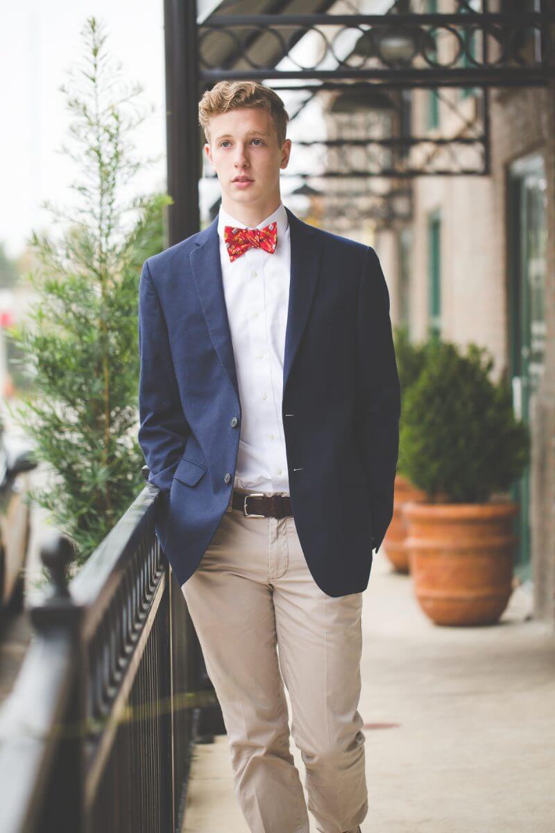 young men's high school senior portrait senior in sport coat and bow tie downtown