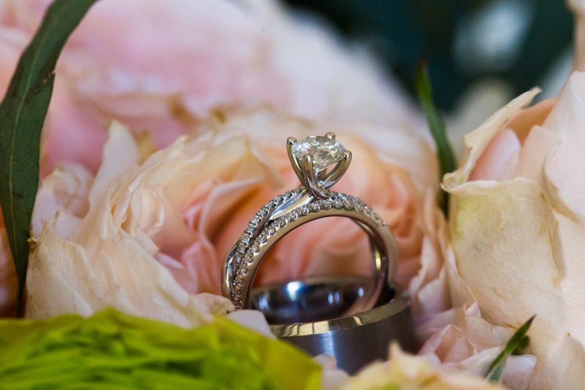 diamond and platinum wedding rings nestled in wedding bouguet